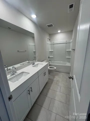 a bathroom with a double vanity sink a mirror and a bathtub