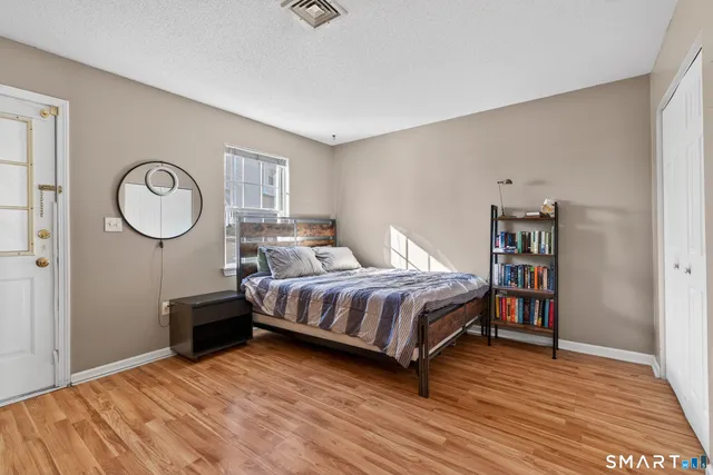 a bedroom with a bed a dresser and bookshelf