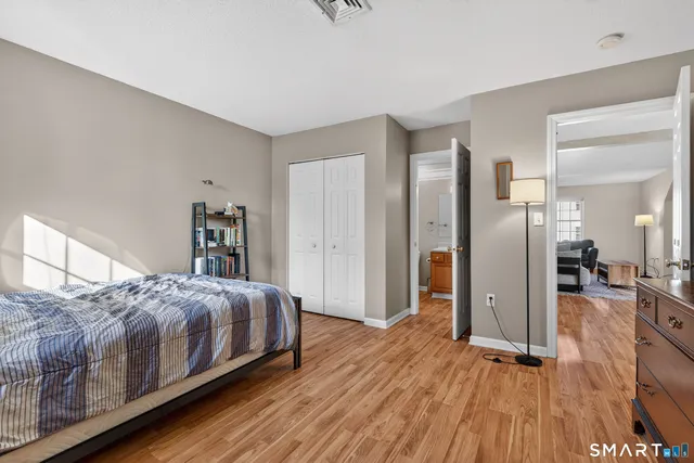 a bedroom with a bed and wooden floor