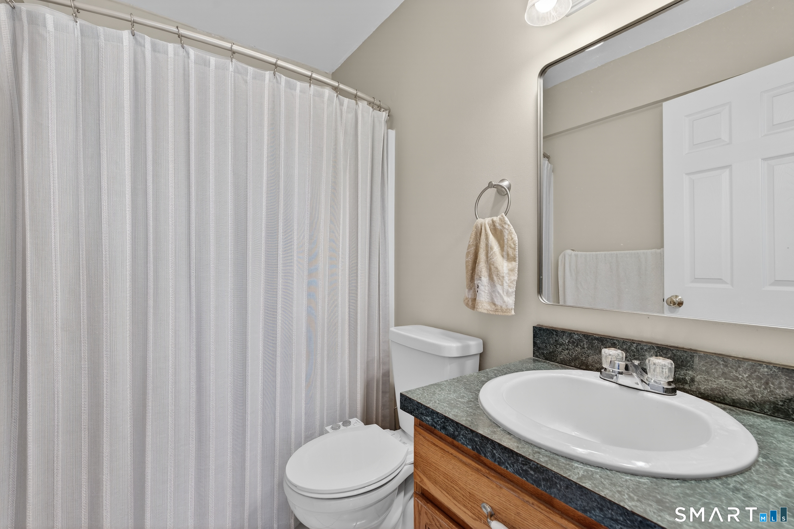 2390 State Street, Unit L17C Hamden, CT 06517 - Photo 17 of 23 a bathroom with a sink a toilet and a mirror