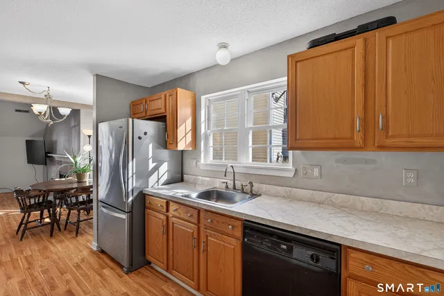 a kitchen with stainless steel appliances granite countertop a refrigerator and a sink