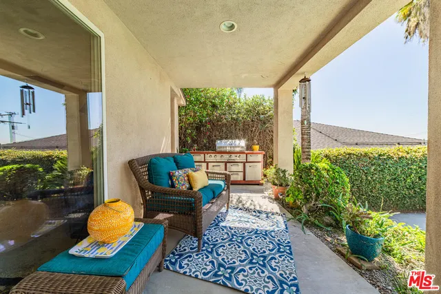 a balcony with potted plants and a bench