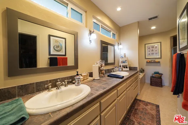 a bathroom with a double vanity sink and a mirror