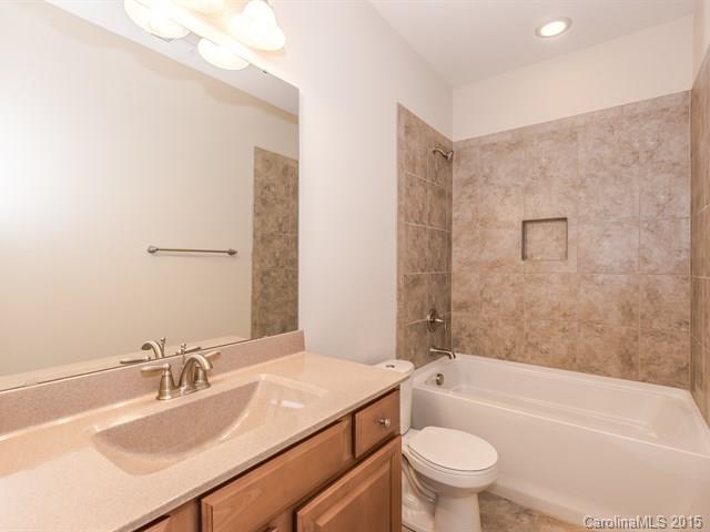 1434 Cilantro Court, Unit 285 Tega Cay, SC 29708 - Photo 13 of 24 a bathroom with a granite countertop sink a toilet and shower