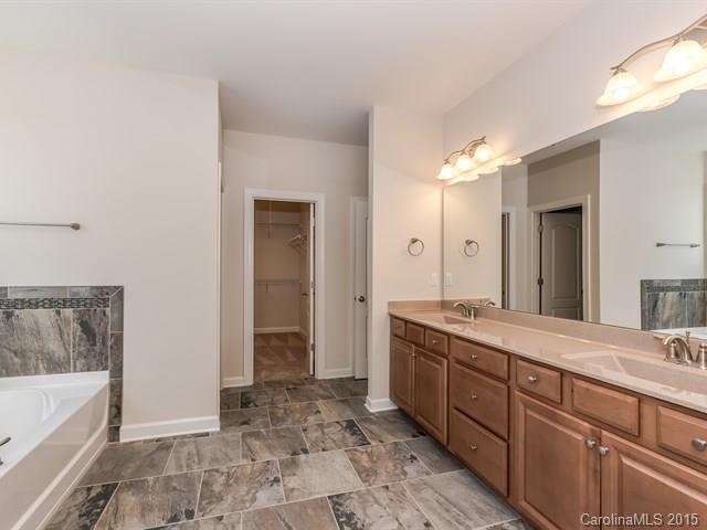1434 Cilantro Court, Unit 285 Tega Cay, SC 29708 - Photo 16 of 24 a spacious bathroom with a granite countertop sink a mirror and a bathtub