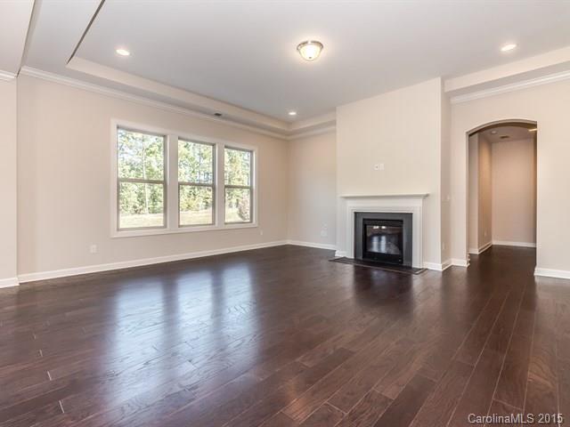 1434 Cilantro Court, Unit 285 Tega Cay, SC 29708 - Photo 9 of 24 an empty room with wooden floor fireplace and windows