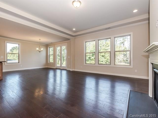 1434 Cilantro Court, Unit 285 Tega Cay, SC 29708 - Photo 10 of 24 a view of an empty room with wooden floor and a window