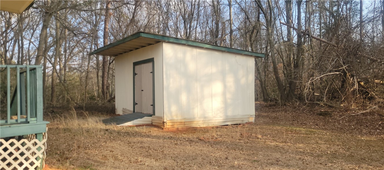 517 Dalton Road Piedmont, SC 29673 - Photo 10 of 12 This outdoor shed offers practical storage solutions amidst a natural, wooded setting.