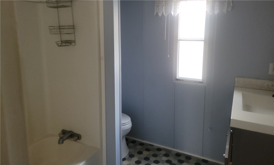 517 Dalton Road Piedmont, SC 29673 - Photo 6 of 12 Functional bathroom featuring a tub, toilet, and sink with a window providing natural light.