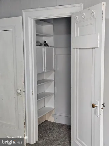 a view of walk in closet with empty racks
