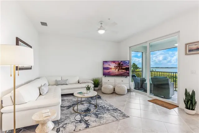 a living room with furniture a rug and a potted plant