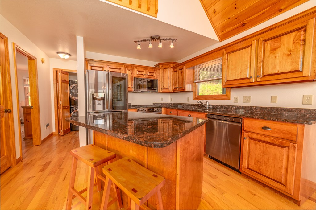 730 Dillon Oaks Drive Murphy, NC 28906 - Photo 13 of 38 a large kitchen with stainless steel appliances granite countertop a refrigerator a stove and a wooden cabinets