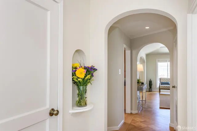 a hallway with painting and a potted plant