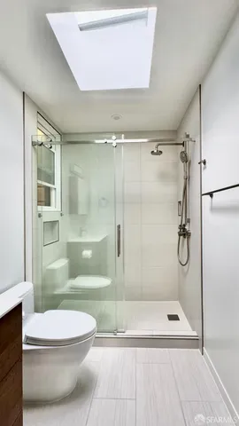 a bathroom with a shower a toilet and shower