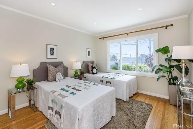 a white bed sitting in a bedroom next to a window