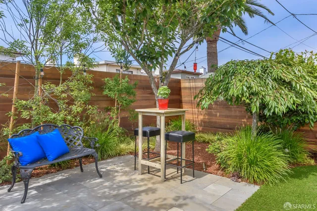 a backyard of a house with chairs and a tree