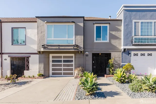 a front view of a house with potted plants