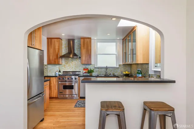 a kitchen with stainless steel appliances a sink stove and refrigerator