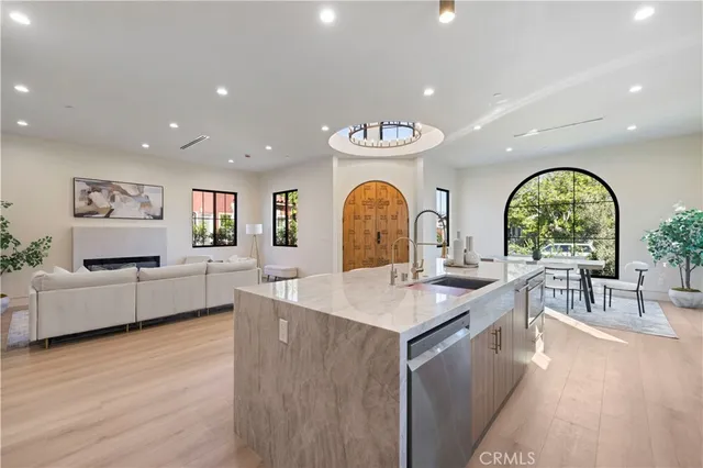 a kitchen with a dining table chairs stainless steel appliances and windows