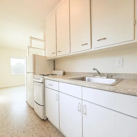 a kitchen with granite countertop white cabinets and white appliances