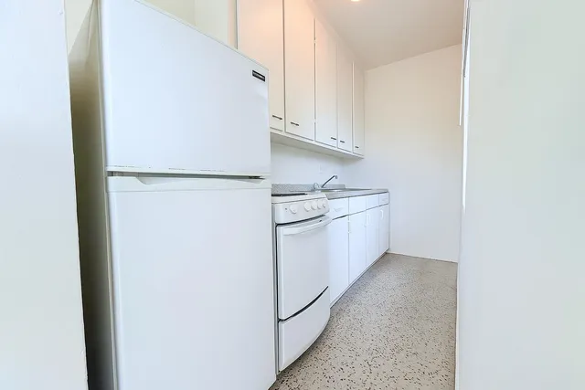 a kitchen with white cabinets and white stainless steel appliances