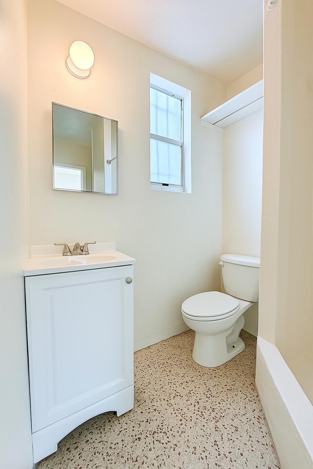 528 58th Street, Unit 1/2 West Palm Beach, FL 33407 - Photo 7 of 8 a bathroom with a toilet a sink and mirror