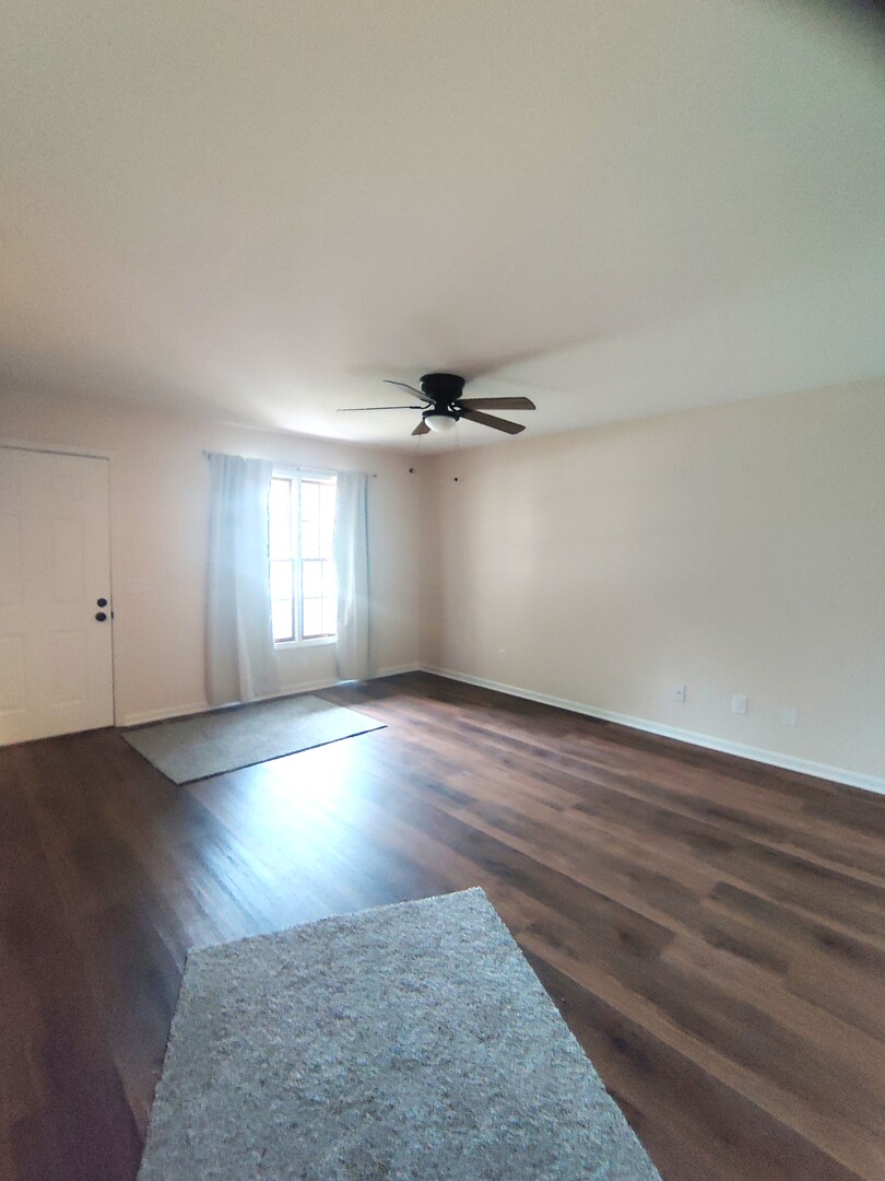 117 Colonial Parkway, Unit A Yorkville, IL 60560 - Photo 2 of 12 an empty room with wooden floor and windows
