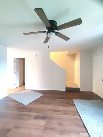 a view of a big room with wooden floor and windows