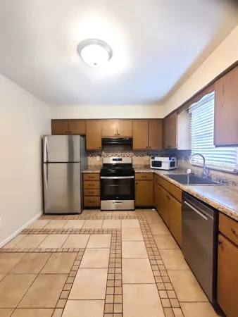 a kitchen with granite countertop a refrigerator and a sink