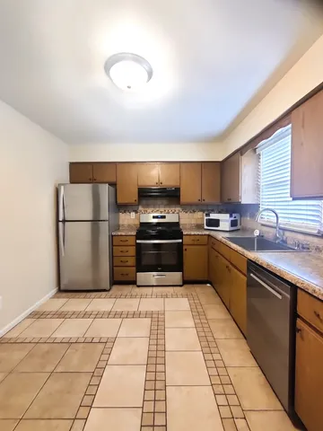 a kitchen with granite countertop a refrigerator and a sink