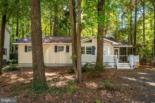 a white house that has a tree in front of a house