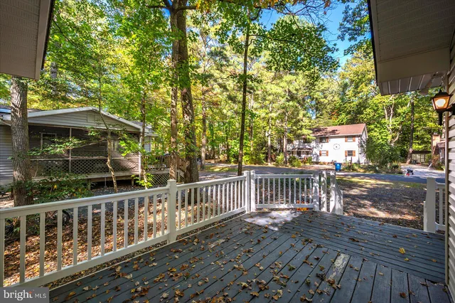 an aerial view of a residential houses with outdoor space and trees all around