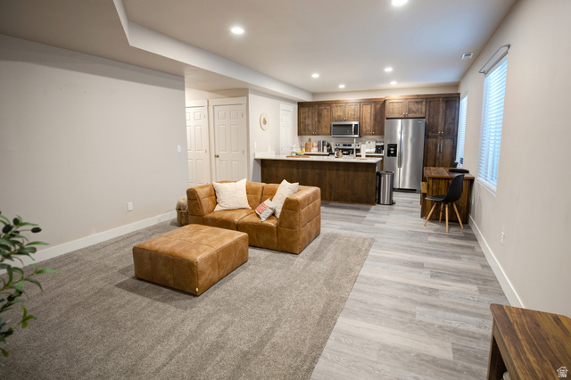 983 South 950 West Provo, UT 84601 - Photo 28 of 56 Open-concept living space with recessed lighting, featuring wood-finish flooring and a full kitchen with dark wood cabinetry, stainless steel appliances, and a white countertop island
