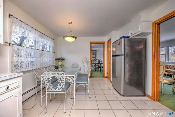 a dining room with furniture and a refrigerator