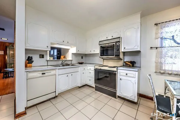 a kitchen with granite countertop cabinets stainless steel appliances and a counter space