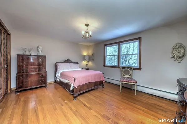 a spacious bedroom with a bed and a chandelier