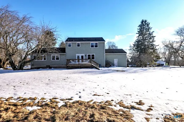 a front view of a house with a yard covered in snow