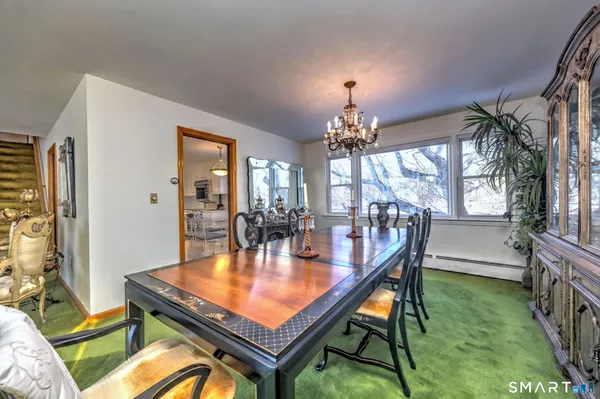 a dining room with chandelier and wooden floor