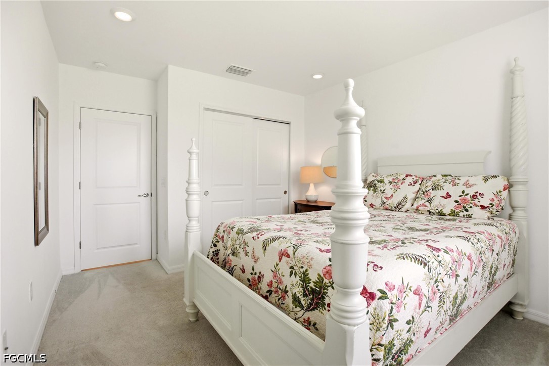3751 Pebblebrook Ridge Court, Unit 101 Fort Myers, FL 33905 - Photo 25 of 48 a bedroom with a large bed and a chandelier