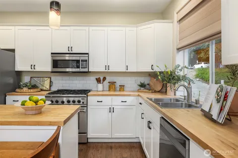 a kitchen with appliances a sink and cabinets