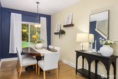 a dining room with furniture a chandelier and wooden floor