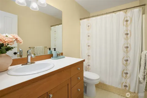 a bathroom with a granite countertop sink a toilet and shower