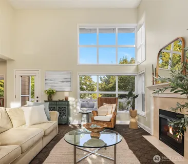 a living room with furniture a fireplace and a large window