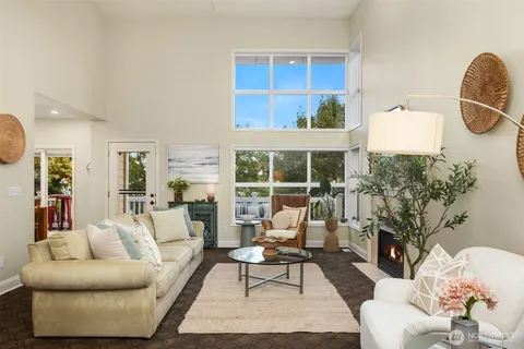 a living room with furniture a fireplace and a floor to ceiling window