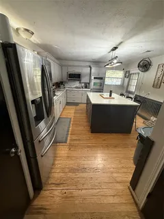 a view of kitchen with sink microwave and refrigerator