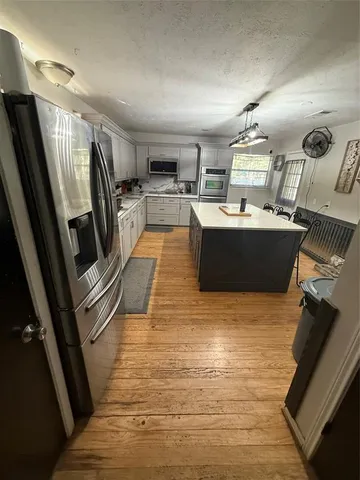 a view of kitchen with sink microwave and refrigerator
