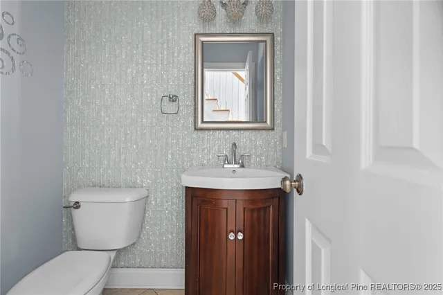 a bathroom with a toilet a sink and mirror