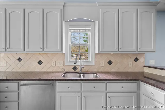 a kitchen with granite countertop white cabinets and sink