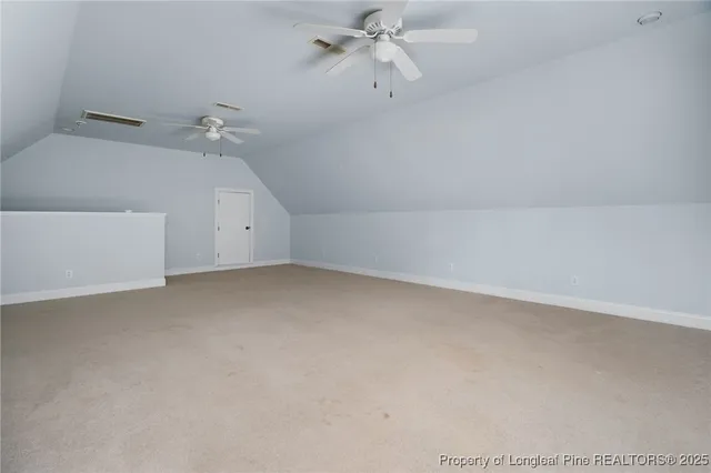 an empty room with windows and ceiling fan
