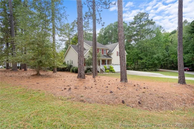 a view of a house with backyard and trees